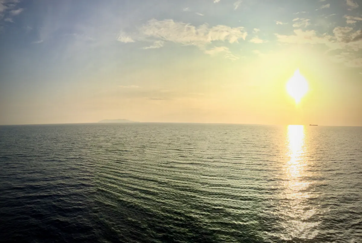 Coucher de soleil doré sur la mer Tyrrhénienne avec bateau à l’horizon