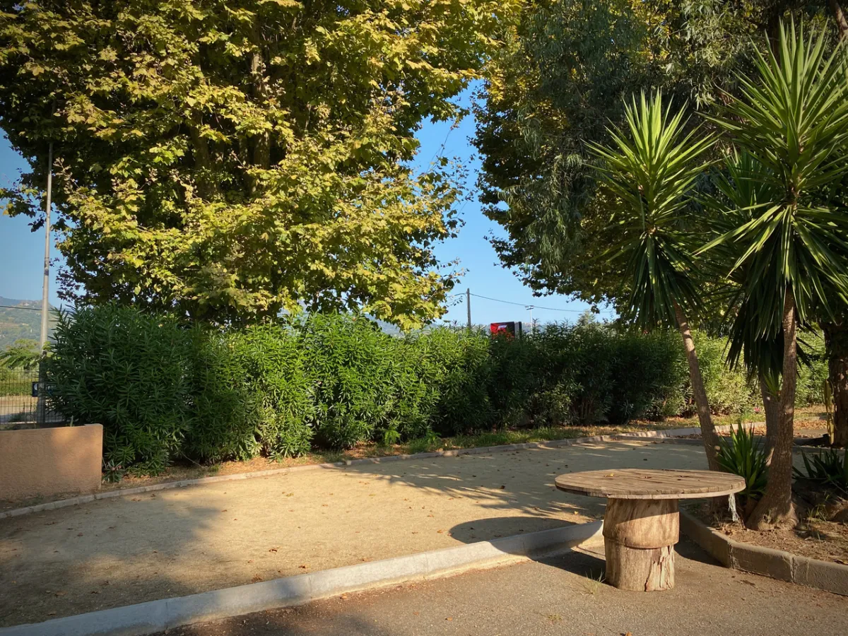 Terrain de pétanque et coin détente dans le jardin de la résidence