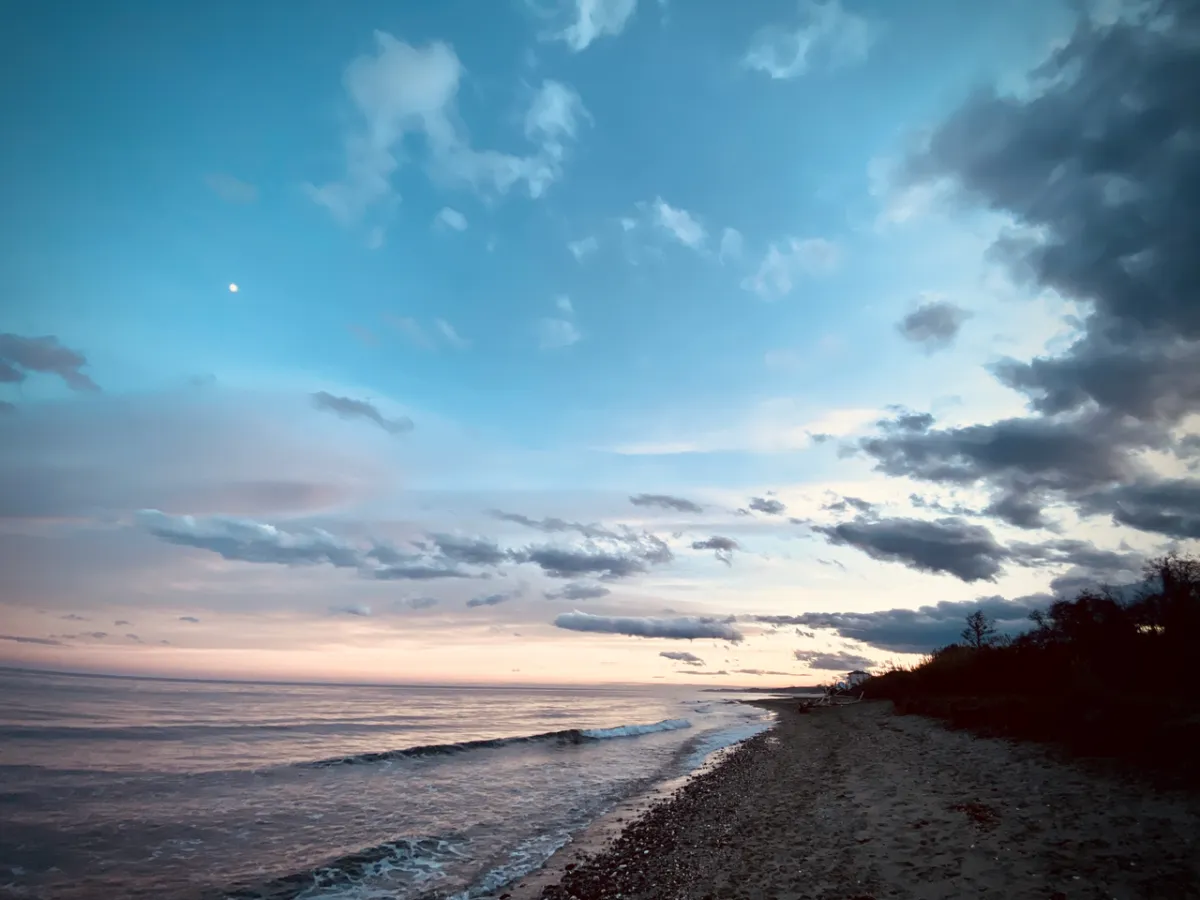 Fin de journée sur la plage, mer calme et ciel rosé