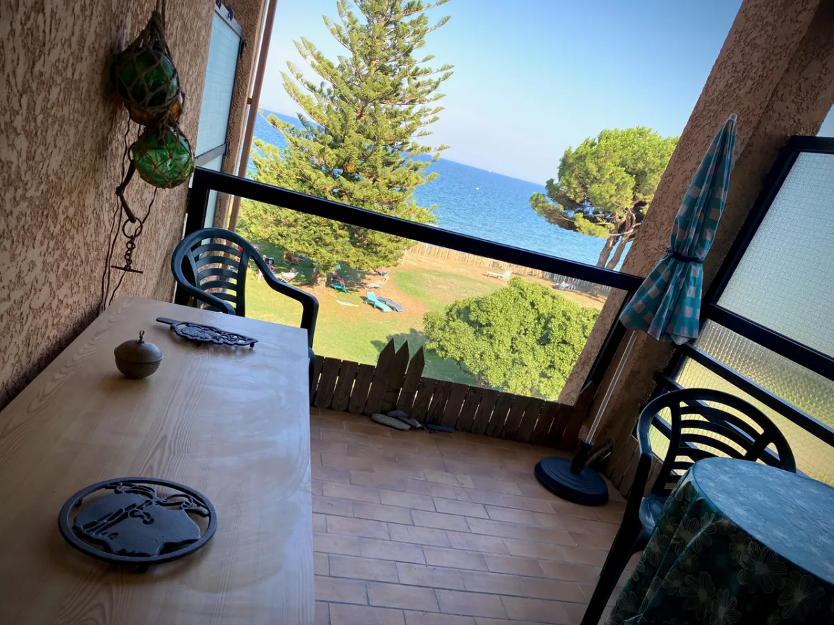 Loggia avec meuble en bois, table extérieure et panorama mer