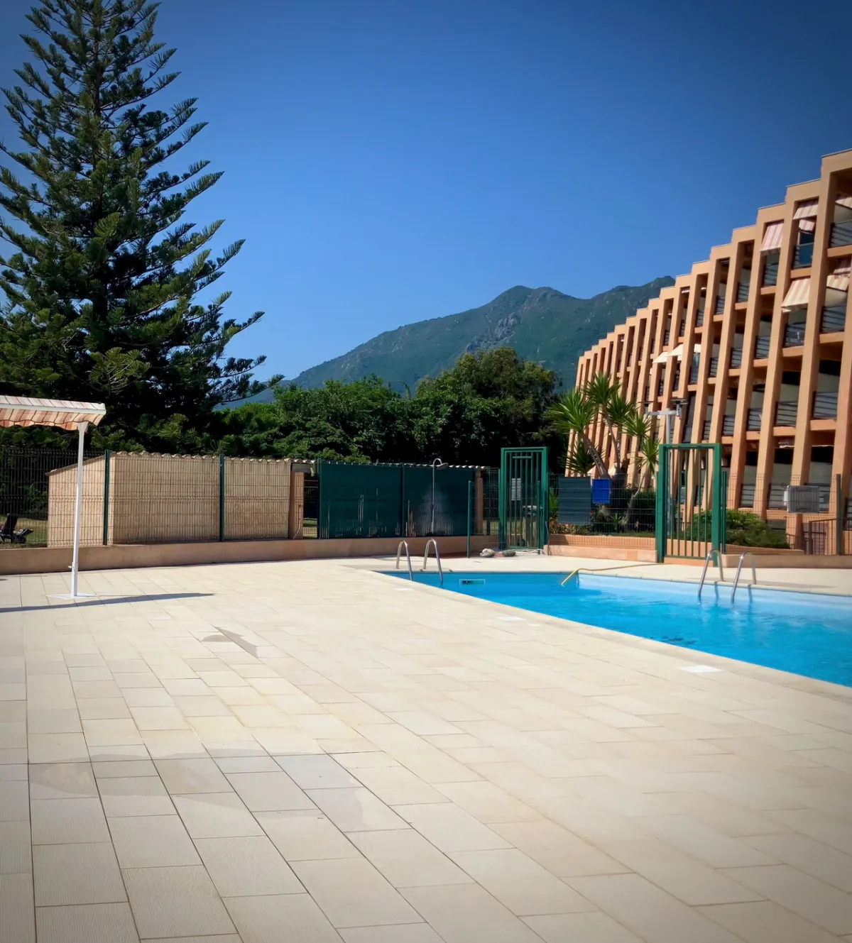 Piscine de la résidence avec montagne en arrière-plan et résidence