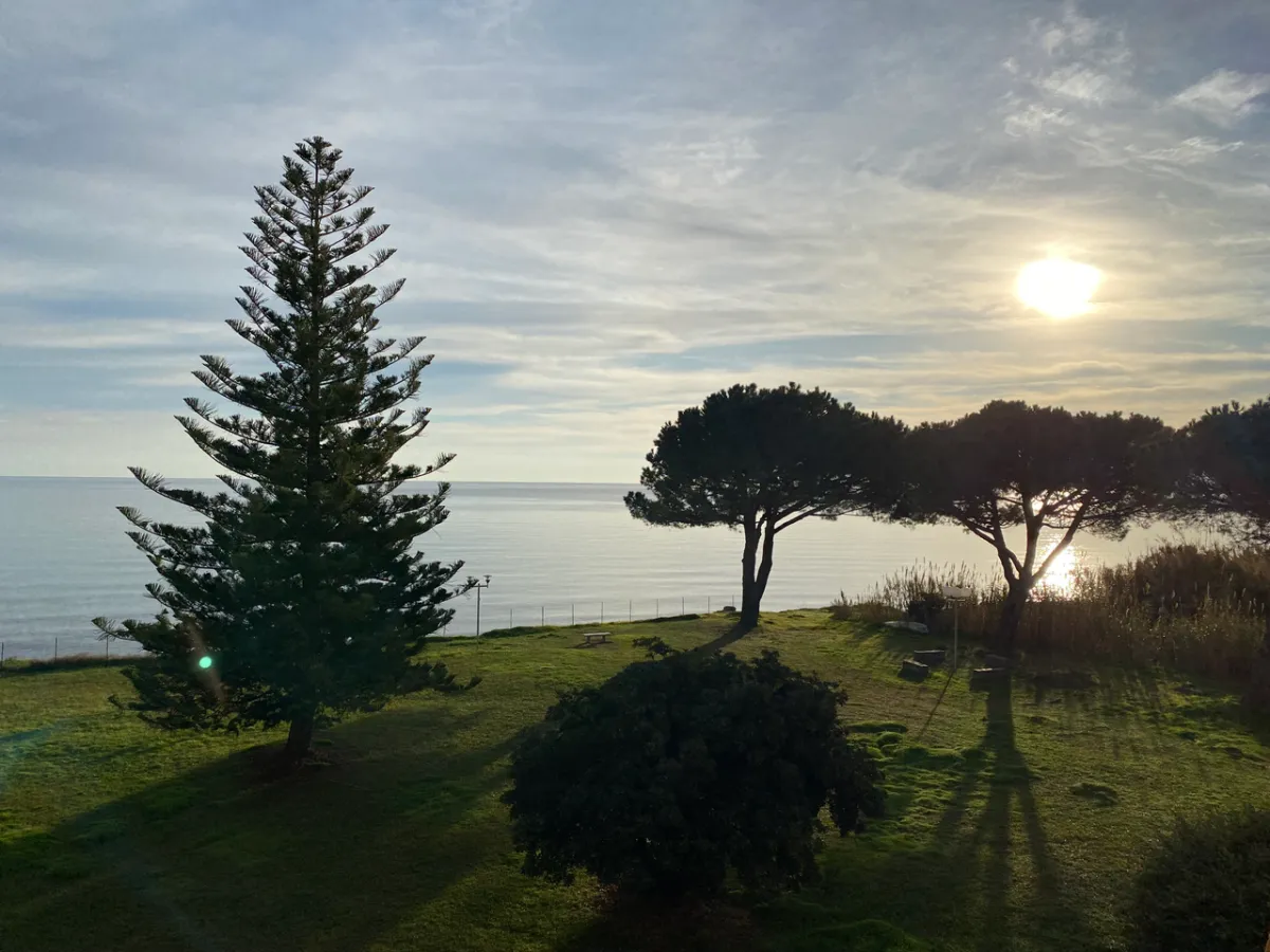 Soleil bas sur la mer, vue depuis la loggia et jardin verdoyant
