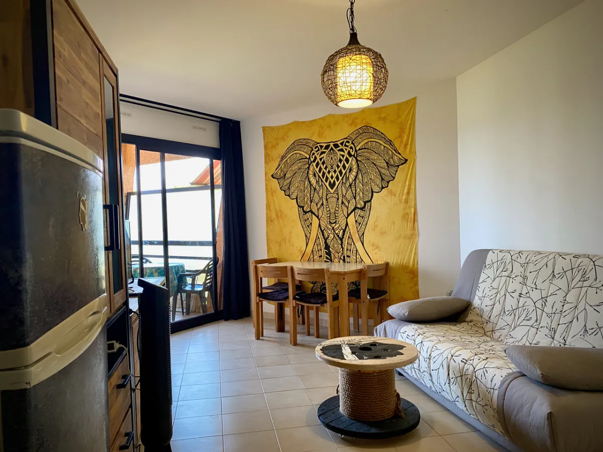 Salon avec canapé-lit et table touret esprit marin, accès loggia